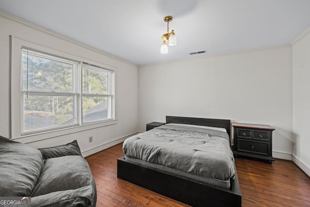 bedroom with ornamental molding and dark hardwood / wood-style floors