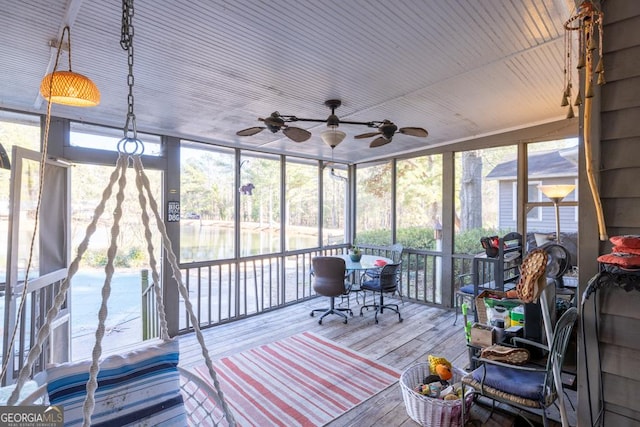 unfurnished sunroom featuring ceiling fan