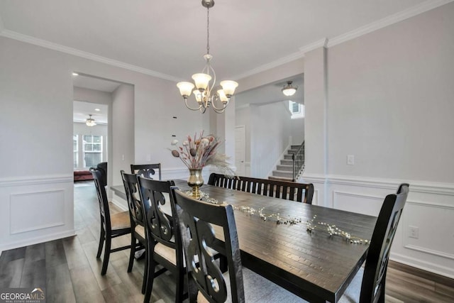 dining space featuring ceiling fan with notable chandelier, dark wood-type flooring, and ornamental molding