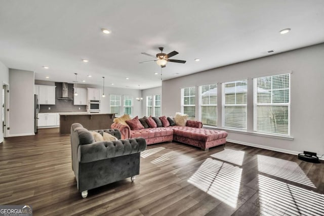 living room featuring dark hardwood / wood-style floors and ceiling fan with notable chandelier