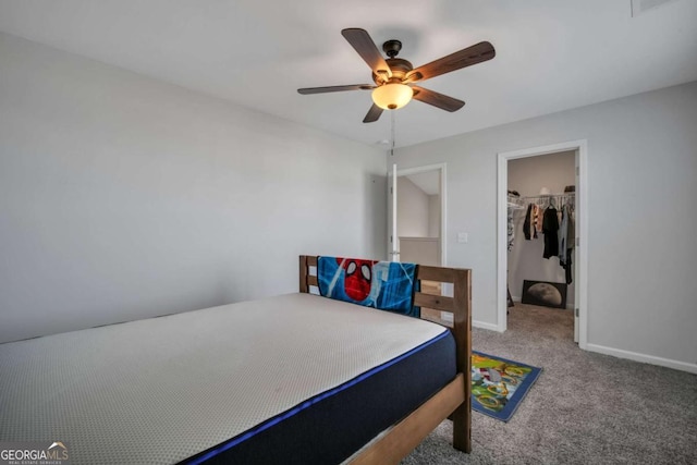 carpeted bedroom with ceiling fan, a spacious closet, and a closet