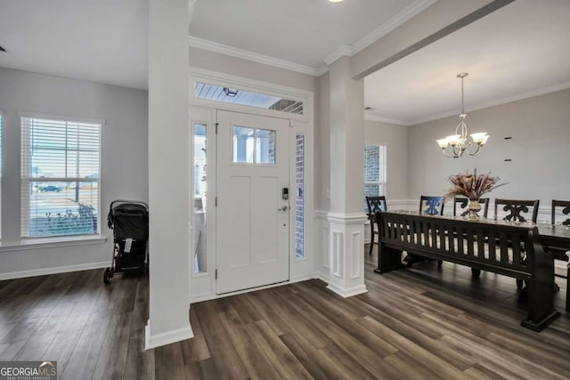 entrance foyer featuring dark hardwood / wood-style flooring, ornamental molding, and an inviting chandelier