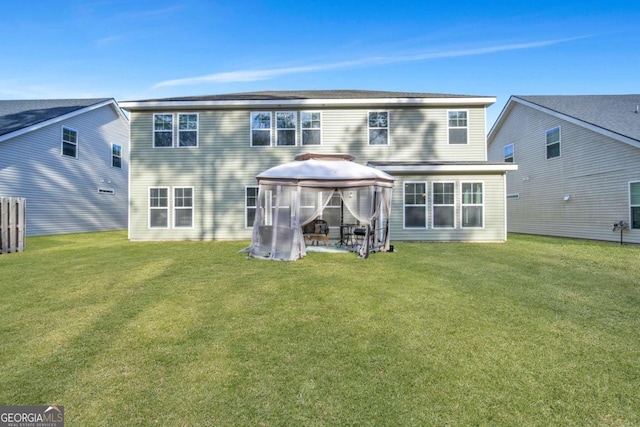 rear view of property with a gazebo and a lawn