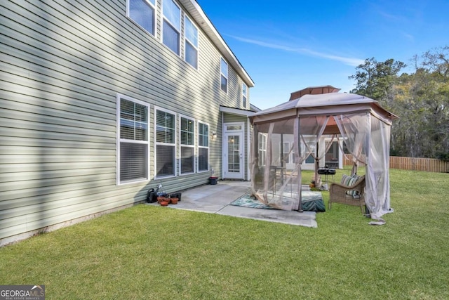 rear view of property with a gazebo, a lawn, and a patio