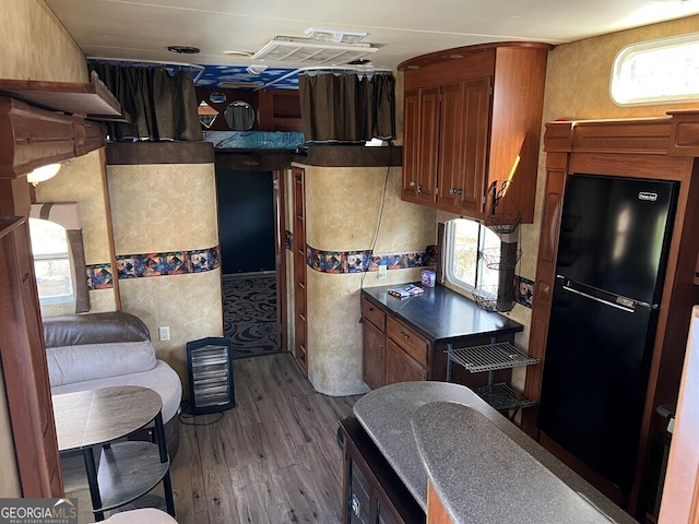 kitchen featuring hardwood / wood-style floors, black fridge, and a wealth of natural light