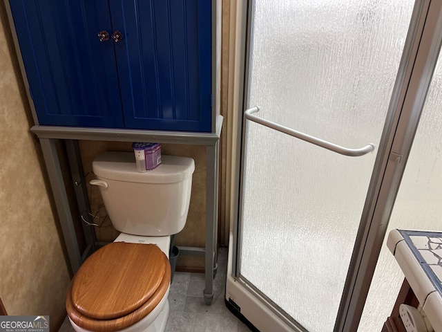 bathroom featuring toilet and tile patterned flooring