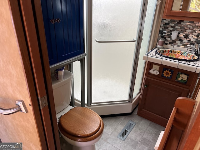 bathroom with toilet, backsplash, and a wealth of natural light