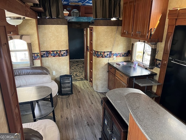 kitchen with light wood-type flooring and black refrigerator