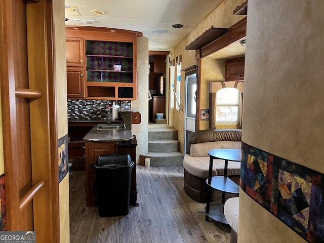 bar with decorative backsplash, dark wood-type flooring, and sink