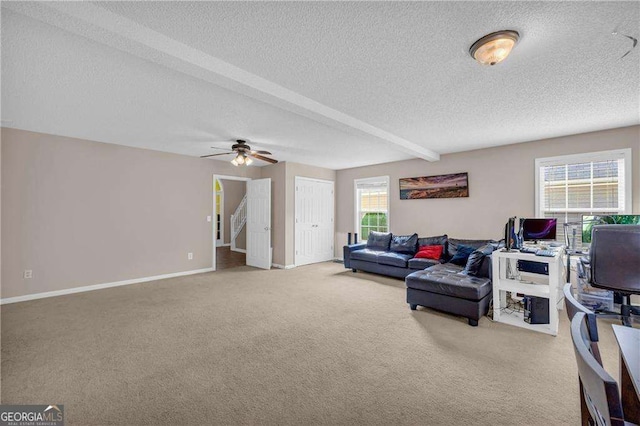 living room featuring ceiling fan, a textured ceiling, carpet, and beam ceiling