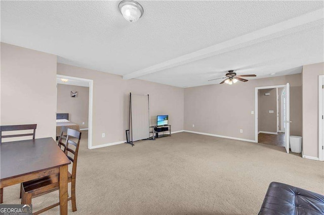 carpeted living room with beam ceiling, ceiling fan, and a textured ceiling