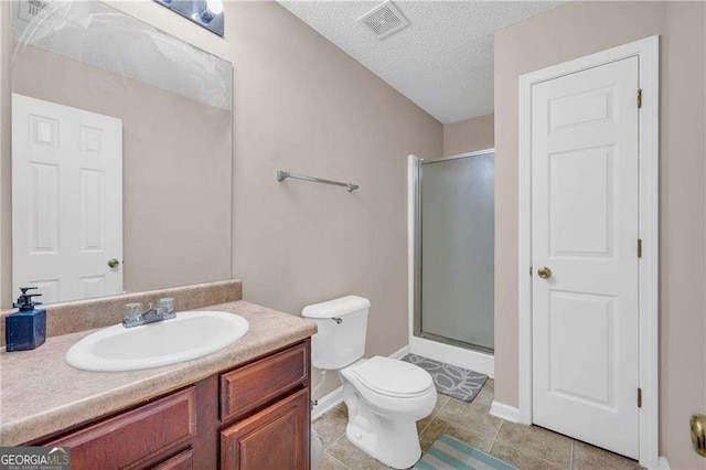 bathroom with a textured ceiling, tile patterned floors, vanity, toilet, and walk in shower