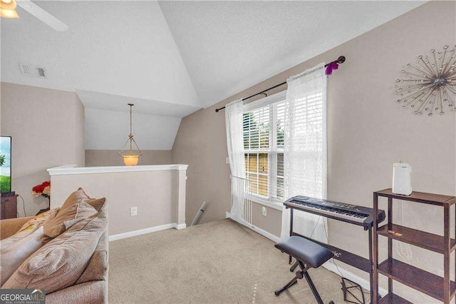 living area with ceiling fan, a textured ceiling, carpet flooring, and vaulted ceiling