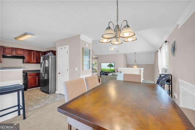 carpeted dining room featuring crown molding, a notable chandelier, and vaulted ceiling