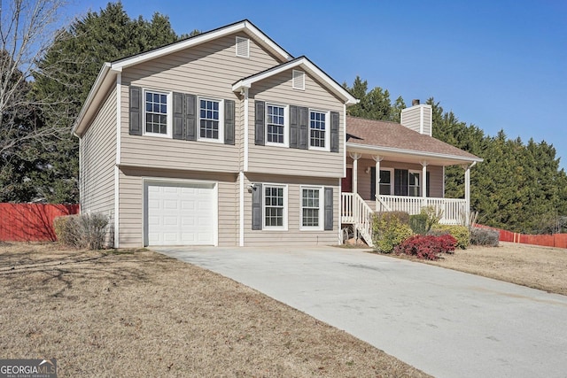 split level home featuring a garage, covered porch, and a front lawn