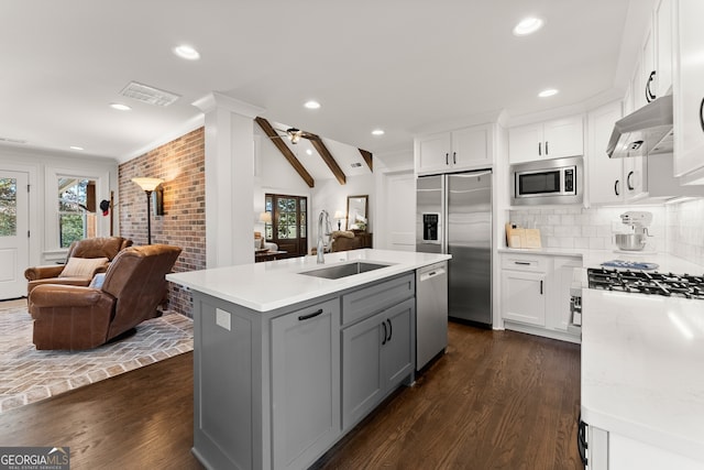 kitchen featuring ceiling fan, white cabinetry, sink, and built in appliances