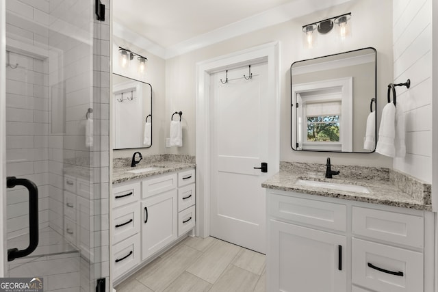 bathroom featuring an enclosed shower, vanity, and ornamental molding