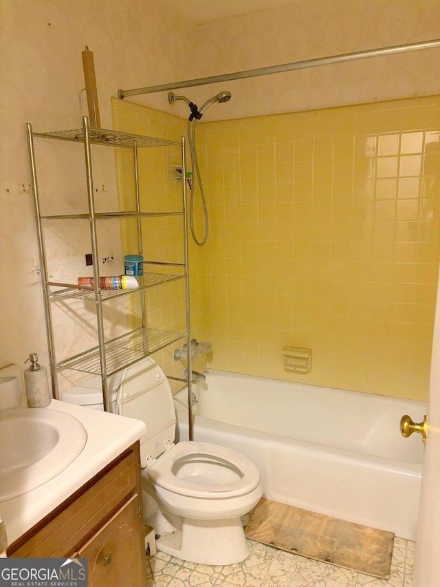 full bathroom with toilet, tile patterned floors, tiled shower / bath, and vanity