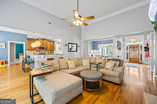 189 Bear Cub Way, Bogart, GA 30622 - living room featuring ornamental molding, a towering ceiling, ceiling fan, light wood-style flooring, and a chandelier