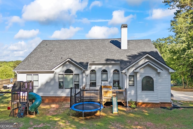 189 Bear Cub Way, Bogart, GA 30622 - rear view of property featuring a deck, a chimney, a trampoline, roof with shingles, and a yard