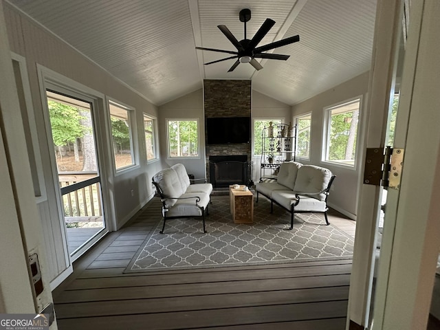 sunroom / solarium with vaulted ceiling, ceiling fan, and a large fireplace