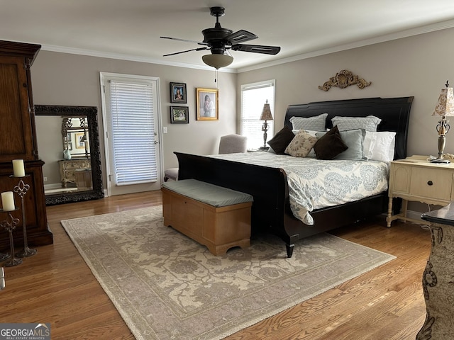 bedroom featuring hardwood / wood-style flooring, ceiling fan, and crown molding