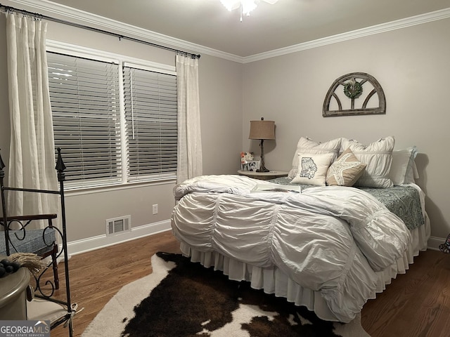 bedroom with dark hardwood / wood-style floors and ornamental molding