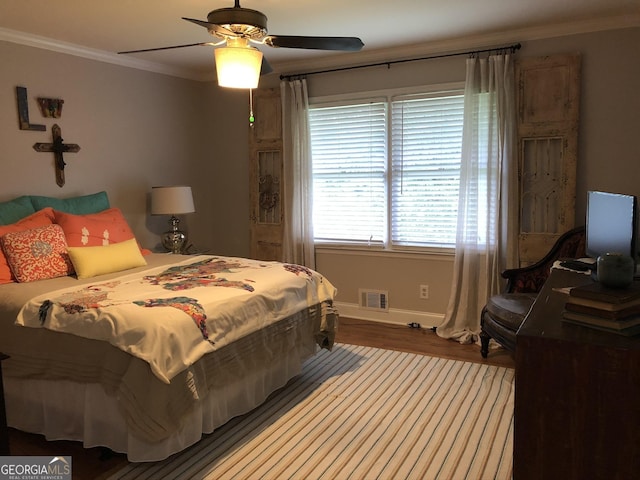 bedroom featuring ceiling fan, wood-type flooring, and ornamental molding