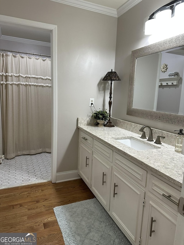 bathroom with ornamental molding, vanity, and wood-type flooring