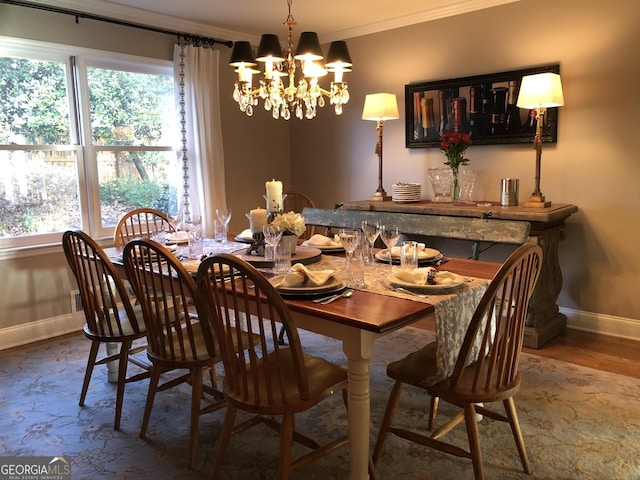 dining area with hardwood / wood-style floors, crown molding, and a notable chandelier