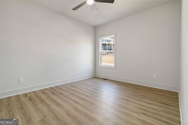 empty room with ceiling fan and light hardwood / wood-style flooring