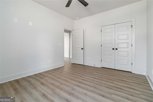 unfurnished bedroom with ceiling fan, a closet, and light hardwood / wood-style flooring