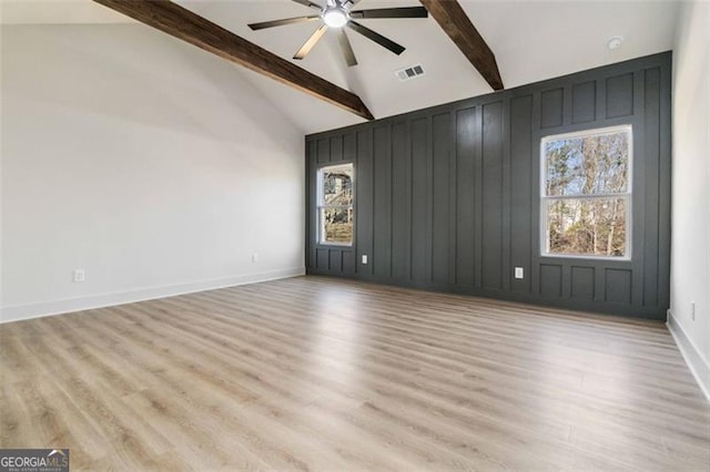 empty room featuring ceiling fan, light hardwood / wood-style flooring, high vaulted ceiling, and beamed ceiling