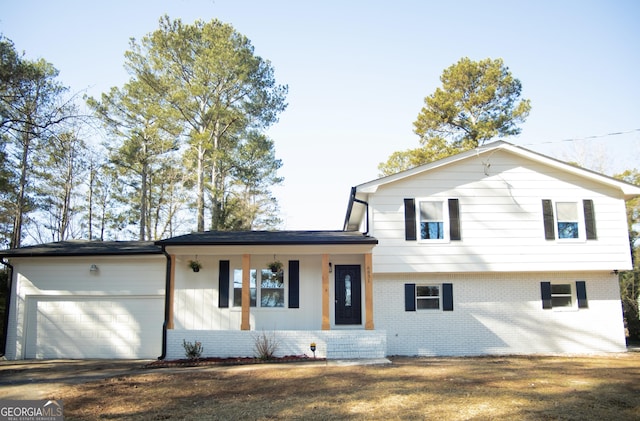 tri-level home featuring covered porch and a garage