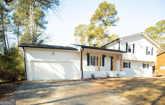 tri-level home with a garage and covered porch