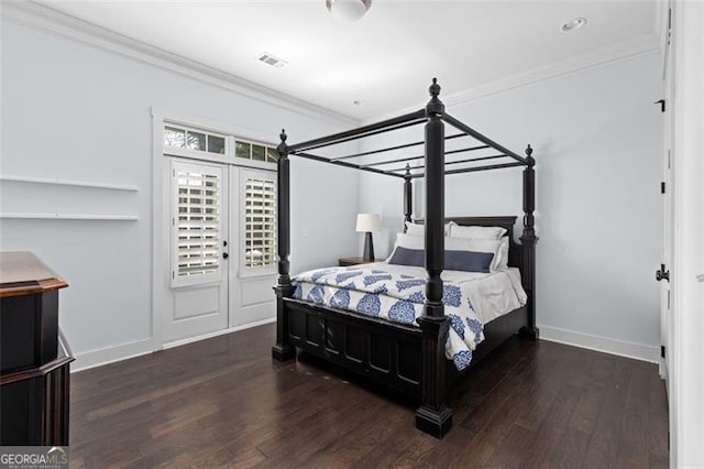 bedroom with ornamental molding, visible vents, baseboards, and wood finished floors