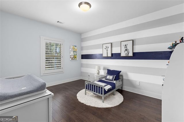 bedroom with wood finished floors, visible vents, and baseboards