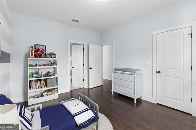 bedroom with visible vents, baseboards, and wood finished floors