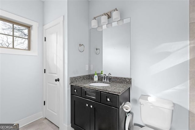 bathroom featuring toilet, tile patterned flooring, baseboards, and vanity