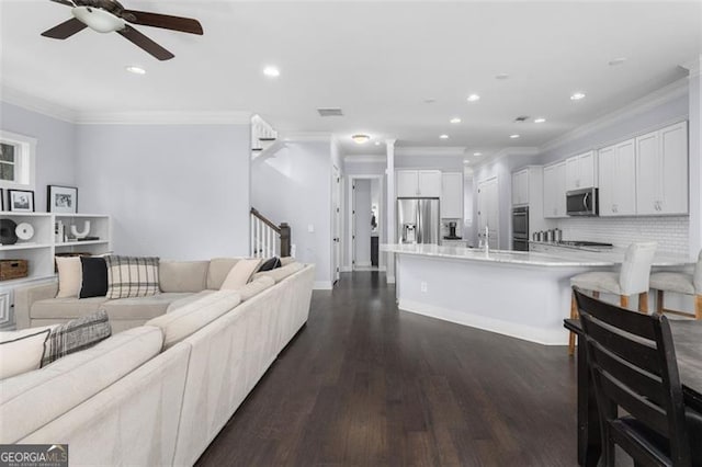 living room featuring ornamental molding, stairway, dark wood finished floors, and recessed lighting