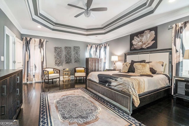 bedroom with ceiling fan, dark hardwood / wood-style flooring, crown molding, and a raised ceiling