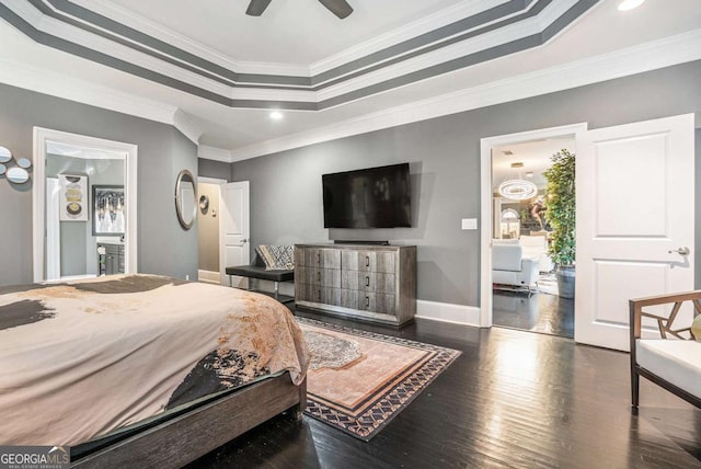 bedroom with ceiling fan, dark wood-type flooring, crown molding, and a tray ceiling