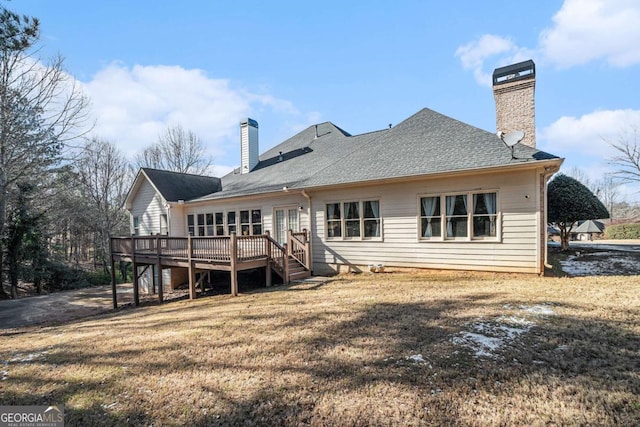 rear view of house featuring a deck and a lawn