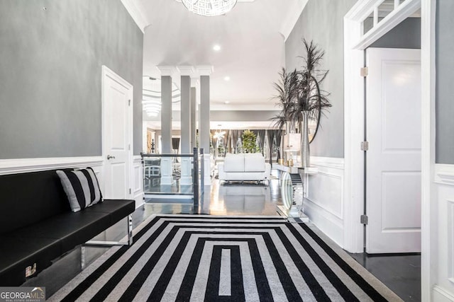 hallway featuring an inviting chandelier and crown molding