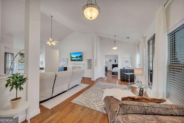 living room featuring ceiling fan, lofted ceiling, and hardwood / wood-style flooring