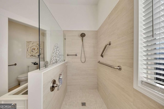 bathroom featuring toilet and tiled shower