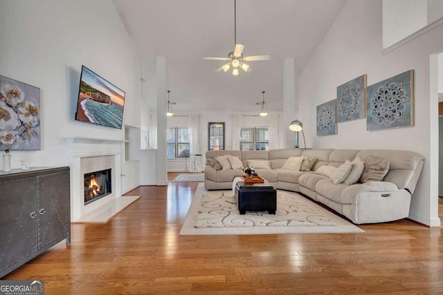 living room featuring hardwood / wood-style flooring, high vaulted ceiling, and ceiling fan