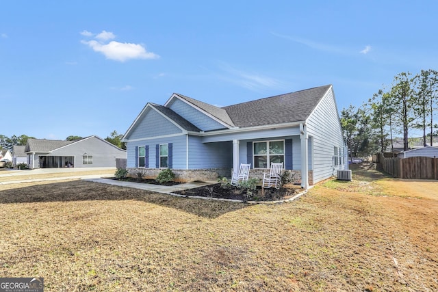 view of front of house with covered porch, a front lawn, and central AC unit