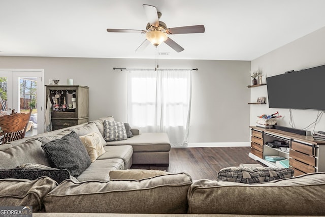 living room featuring dark wood-type flooring and ceiling fan