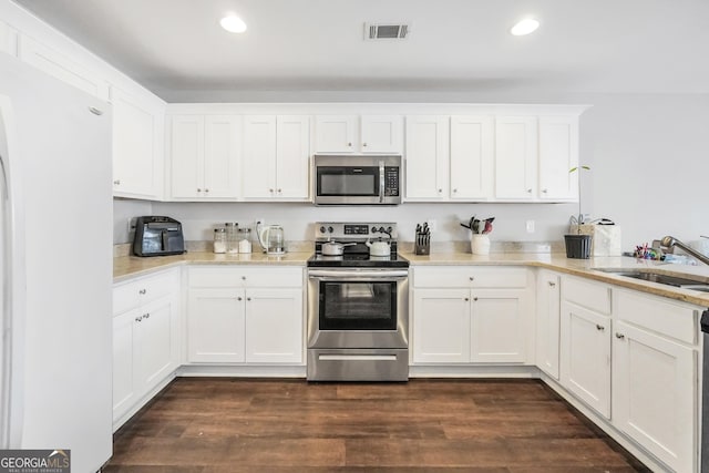 kitchen featuring sink, white cabinets, appliances with stainless steel finishes, and dark hardwood / wood-style floors